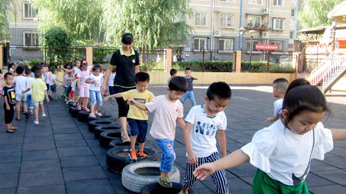 户外活动,带孩子们一起玩轮胎,锻炼幼儿平衡能力,发展幼儿的协调性